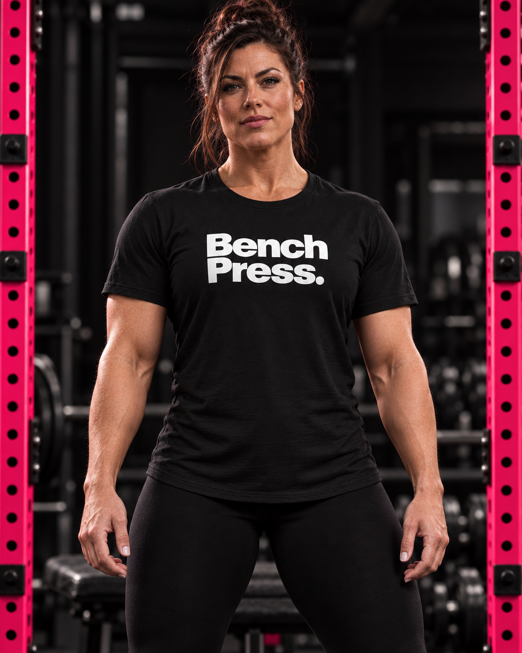 Strong woman wearing black Bench Press unisex tee with white chest print in a gym