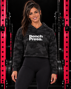 Bench Press. - Cropped Hooded Sweatshirt — collection design in black gym with pink racks