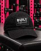 Built Different - Dad Hat with Leather Patch (Rectangle) - White Logo — Built Different collection hero in black and pink gym