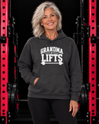 Grandma Lifts white front logo hoodie in Dark Heather on a woman over 60 in the WWLW gym