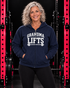 Grandma Lifts white front logo navy full zip hoodie on mature woman in black gym with pink racks