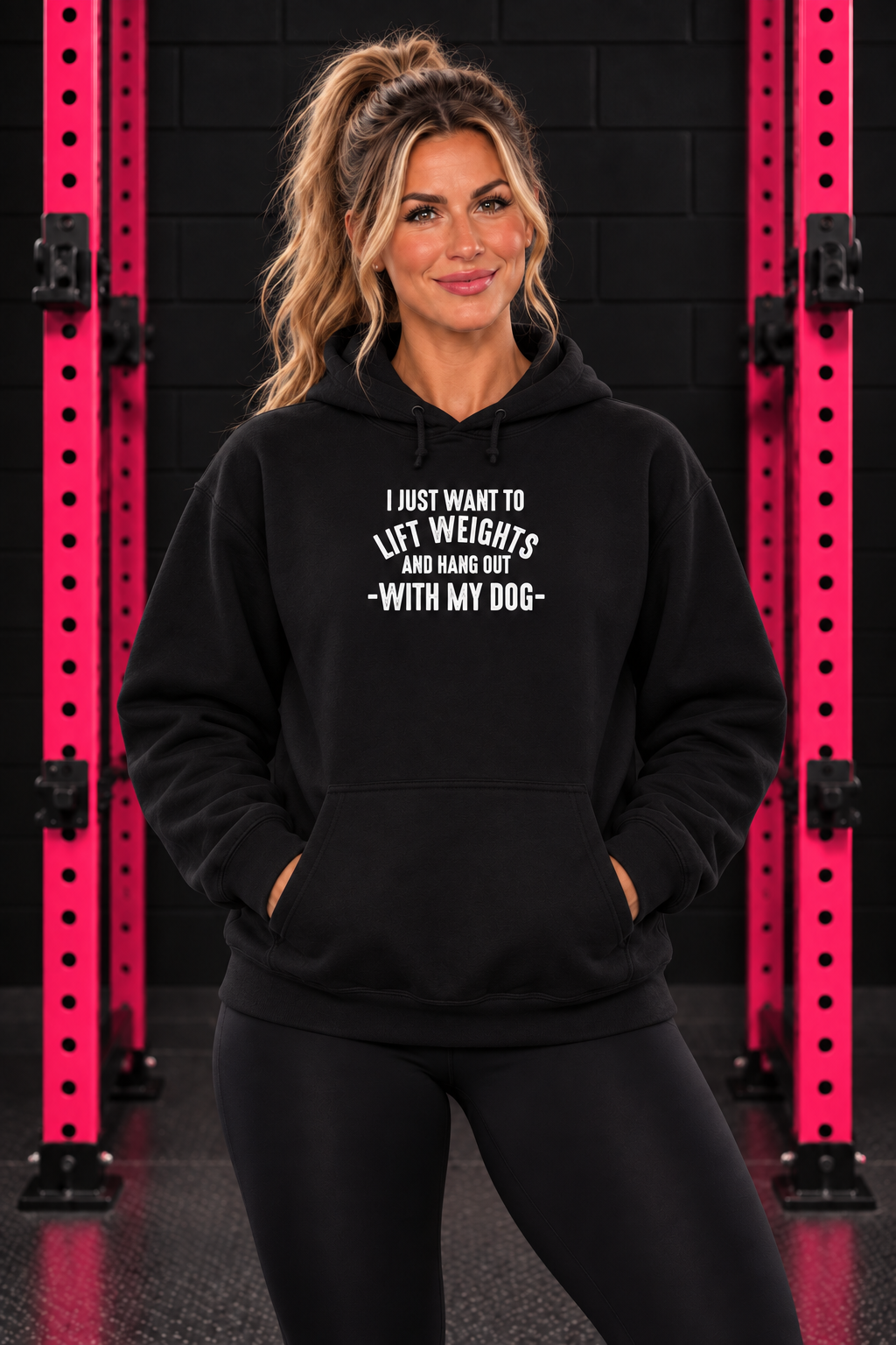 Black Lift Weights and Hang Out With My Dog hoodie, front-facing female model with pink gym rack
