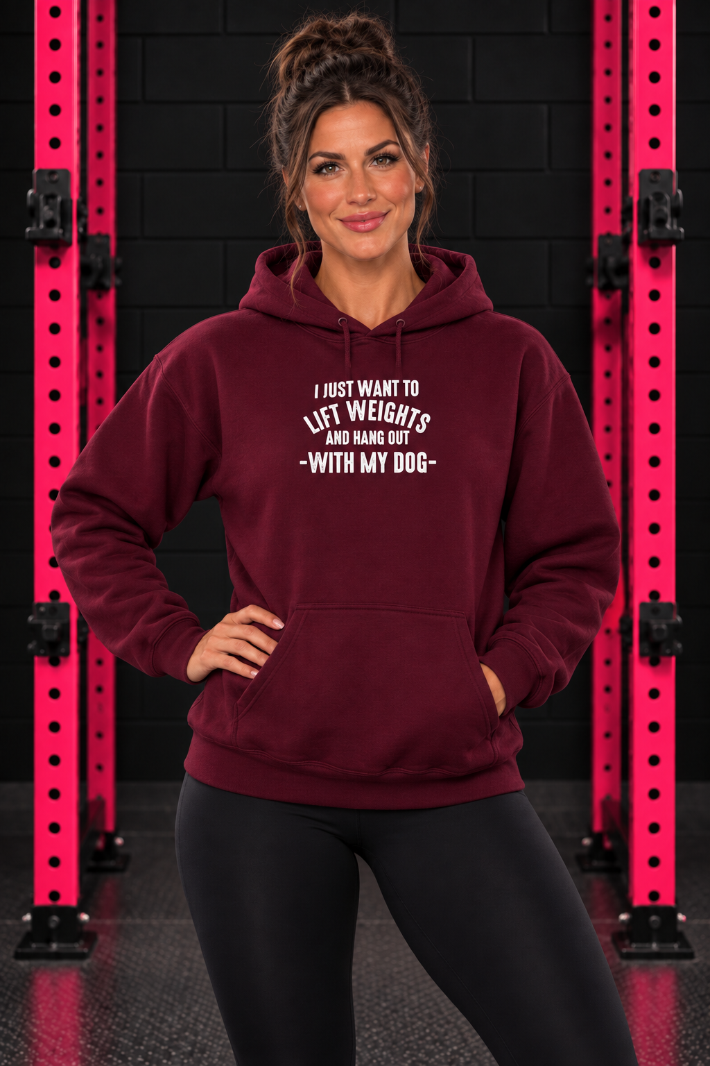 Maroon Lift Weights and Hang Out With My Dog hoodie, front-facing female model with pink gym rack