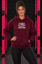 Maroon Lift Weights and Hang Out With My Dog hoodie, front-facing female model with pink gym rack