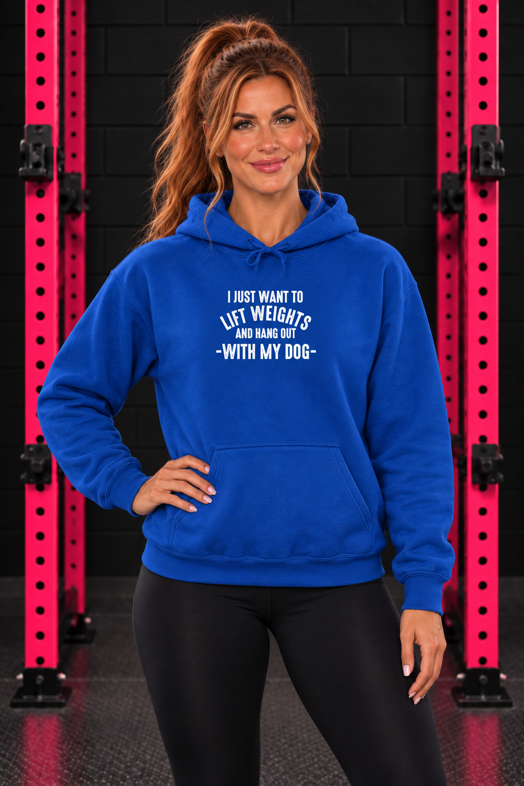Royal Blue Lift Weights and Hang Out With My Dog hoodie, front-facing female model with pink gym rack