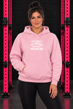 Light Pink Lift Weights and Hang Out With My Dog hoodie, front-facing female model with pink gym rack
