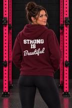 Maroon Strong Is Beautiful hoodie back print, female model between pink squat rack uprights