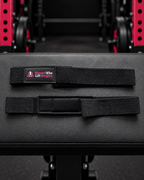 Black WWLW padded lifting straps showing woven fabric, logo and wrist padding.
