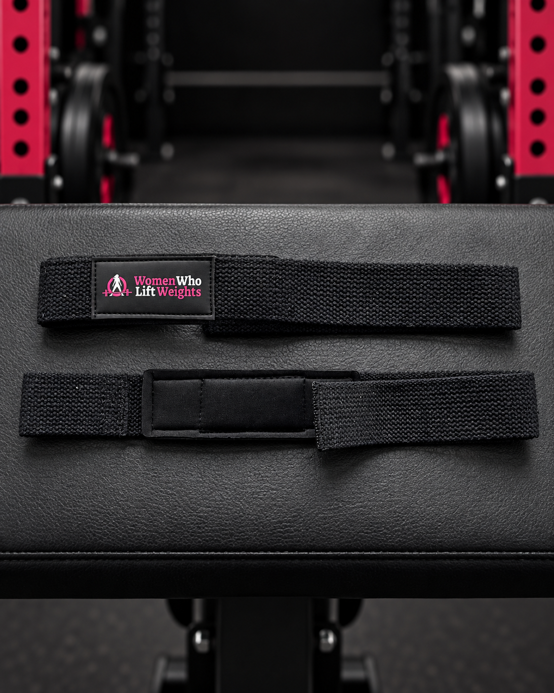 Black WWLW padded lifting straps showing woven fabric, logo and wrist padding.