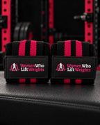 Black and hot pink striped WWLW wrist wraps with stitched logo patches.