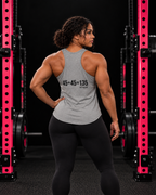 45 + 45 = 135 racerback tank, gray with black back print, worn by an athletic woman in a black and pink gym.