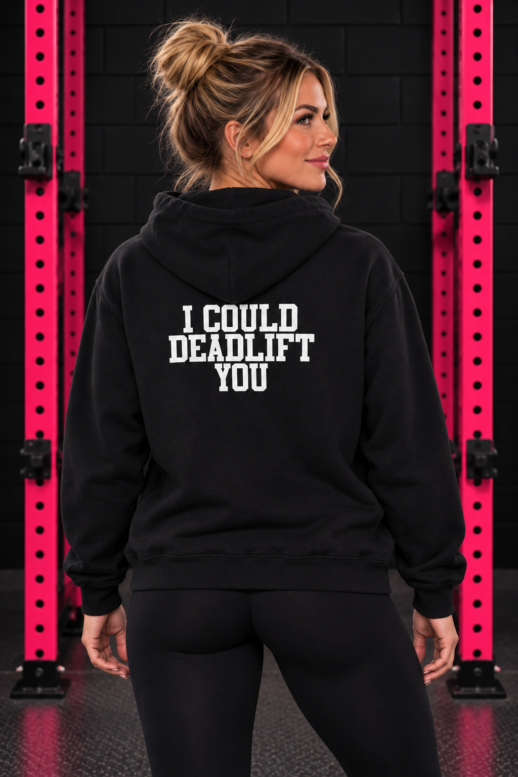 Back view of woman wearing black WWLW hoodie with white I Could Deadlift You print in black and pink gym