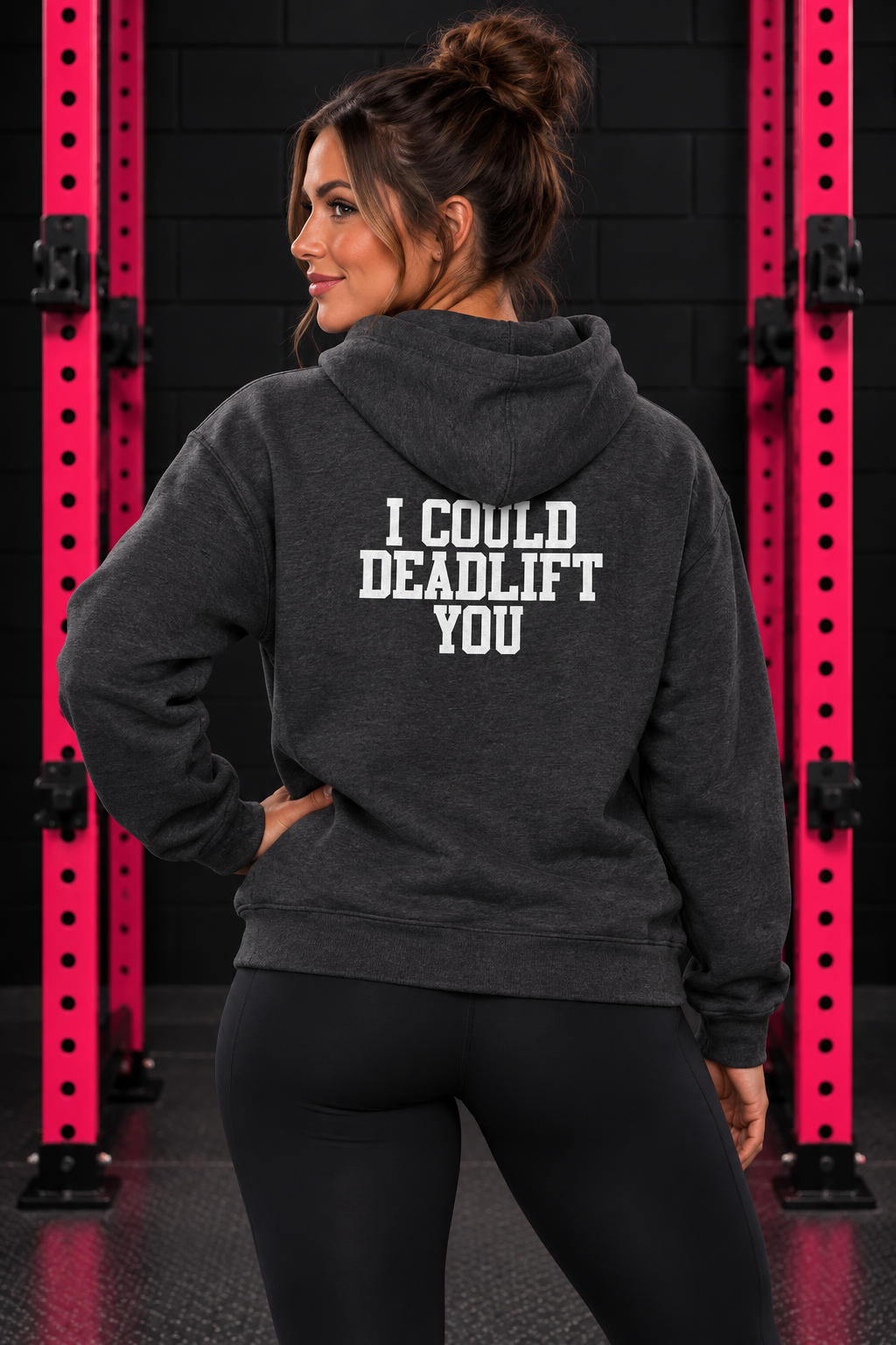 Back view of woman wearing dark heather WWLW hoodie with white I Could Deadlift You print in black and pink gym