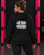 Black hoodie with white slogan back print, modeled in the WWLW black brick and hot-pink rack gym.